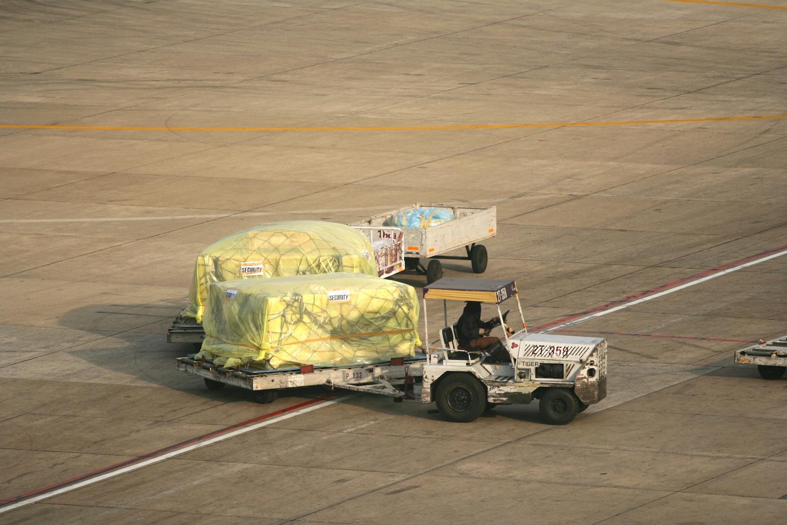 Man Driving Vehicle with Trailers at Airport